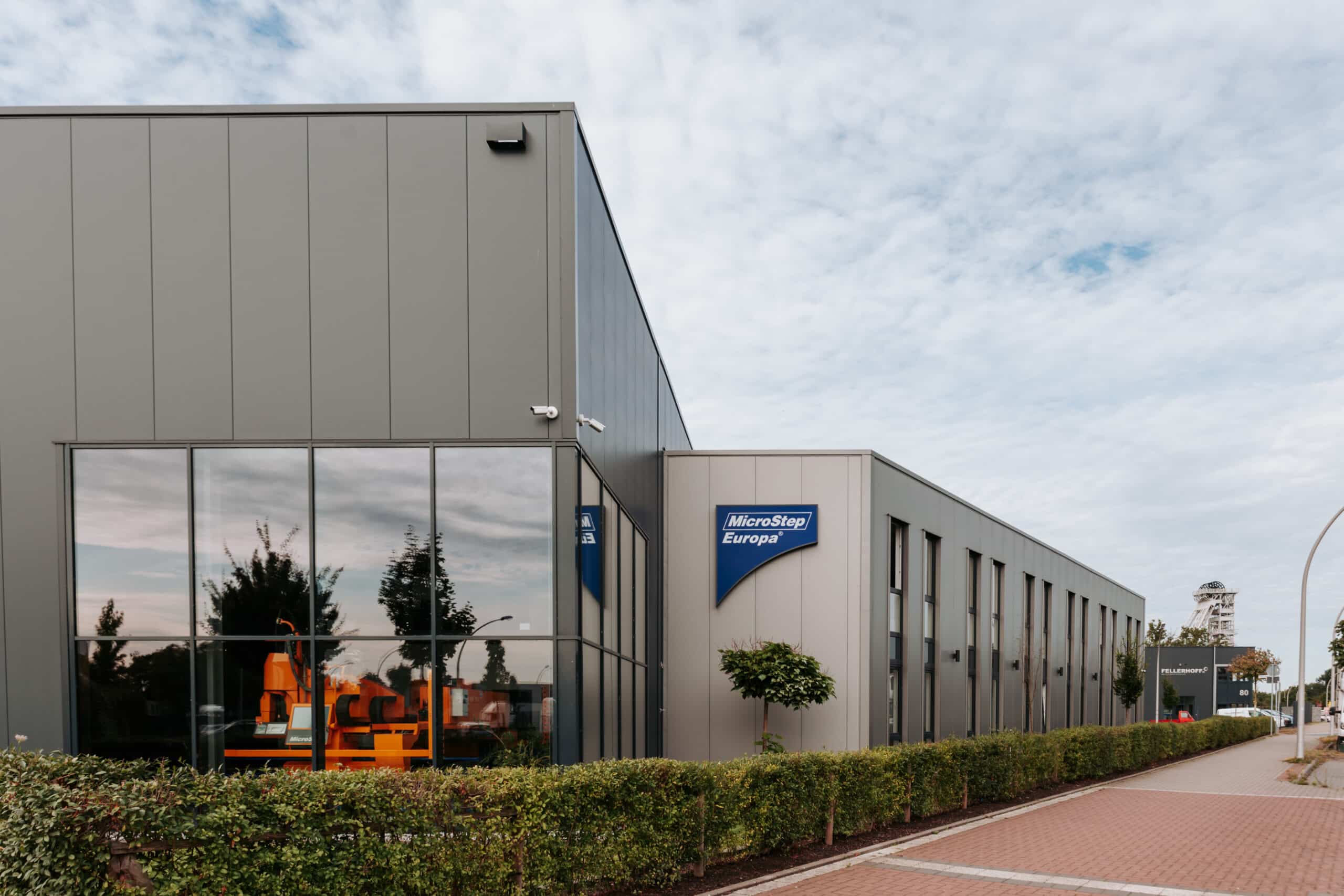 Fassadenansicht des MicroStep-Europa-Gebäudes mit großem Fensterbereich und Firmenlogo.