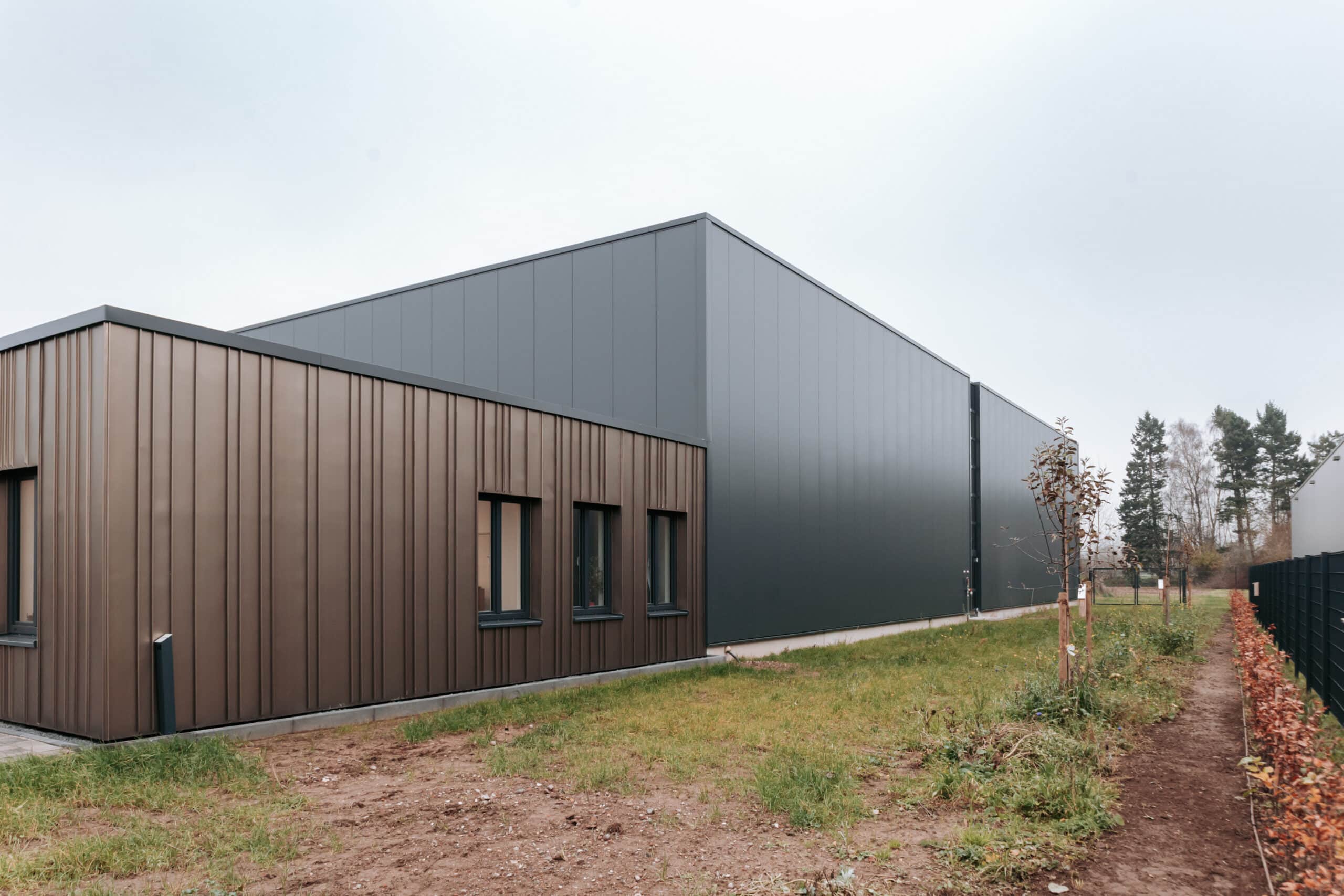 Verwaltungsgebäude mit brauner Metallfassade neben der Produktionshalle in Bocholt.