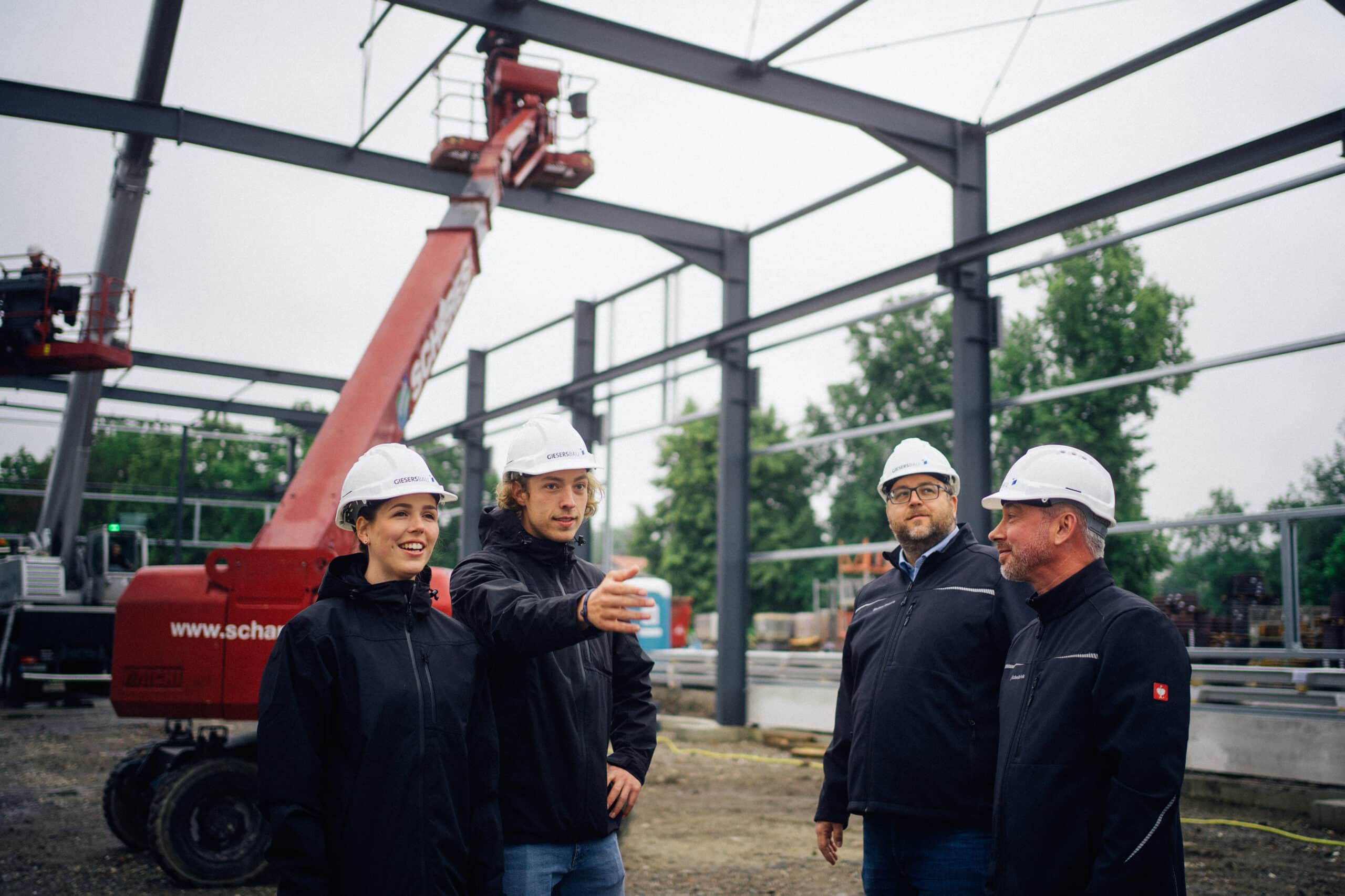 Mehrere Personen mit Bauhelm auf einer Baustelle