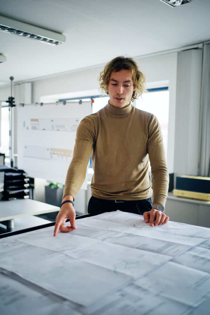 Giesers Bau Mitarbeiter aus der Technik erläutert einen Plan.