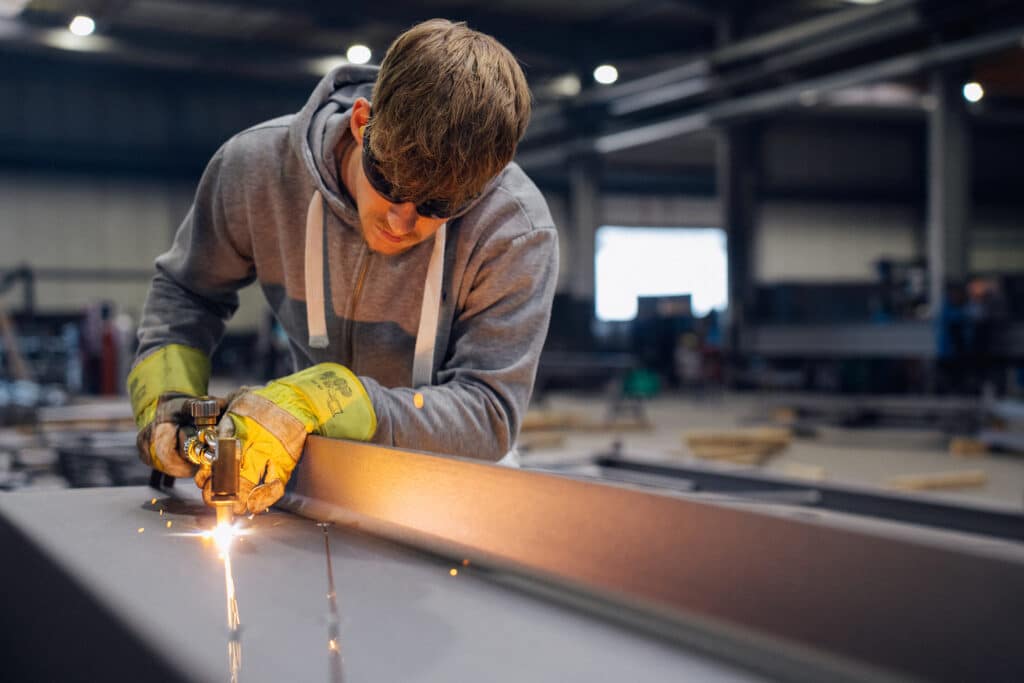 Mitarbeiter von Giesers Bau in der Produktionshalle beim Schweißen.